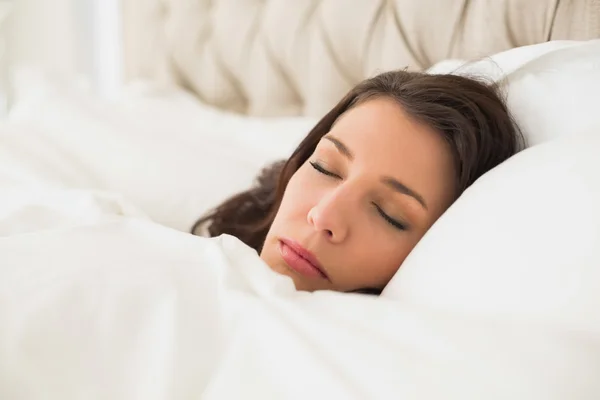 Dromerige mooie vrouw slaapt in haar bed — Stockfoto