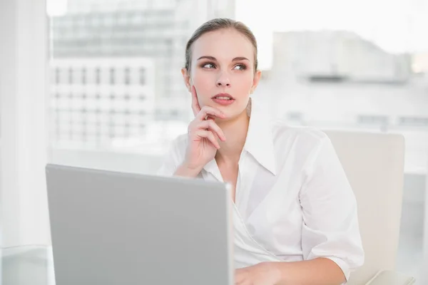 Mujer de negocios reflexivo utilizando el ordenador portátil —  Fotos de Stock