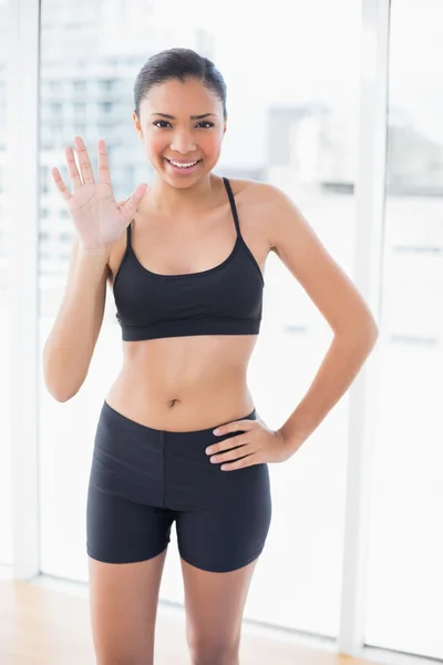 Modelo alegre en ropa deportiva posando y saludando a la cámara — Foto de Stock