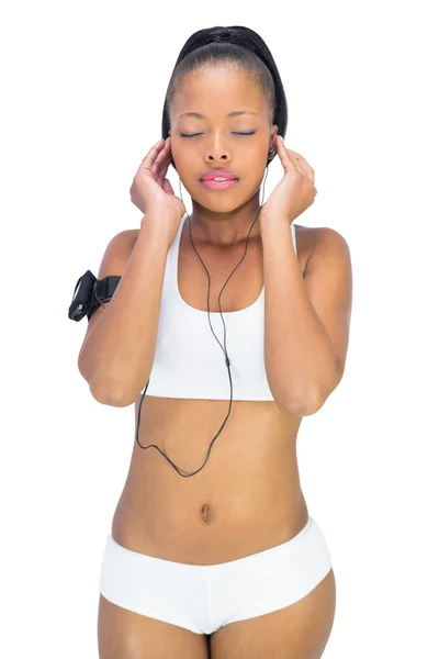 Rauhallinen nainen urheiluvaatteissa kuuntelemassa musiikkia — kuvapankkivalokuva