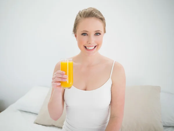 Naturale sorridente bionda in possesso di un bicchiere di succo d'arancia — Foto Stock