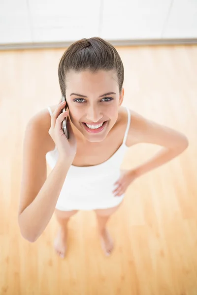 Femme en tenue de sport blanche faisant un appel téléphonique — Photo