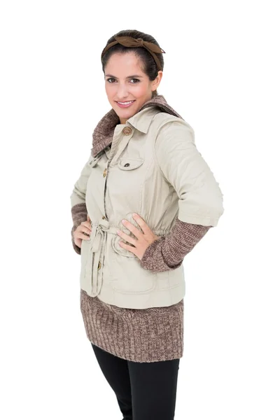 Smiling cute brunette in winter fashion standing with hands on hips — Stock Photo, Image