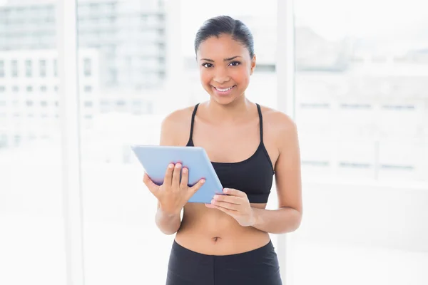 Charming dark haired model in sportswear holding a tablet pc — Stock Photo, Image