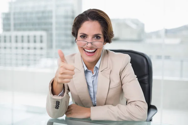 Fröhliche Geschäftsfrau zeigt Daumen hoch am Schreibtisch — Stockfoto