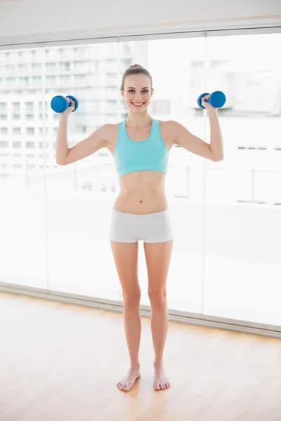 Deportiva sonriente mujer sosteniendo pesas — Foto de Stock