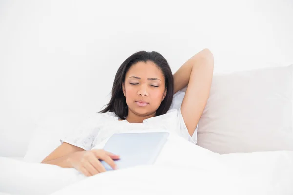 Sleepy young model holding a tablet pc — Stock Photo, Image