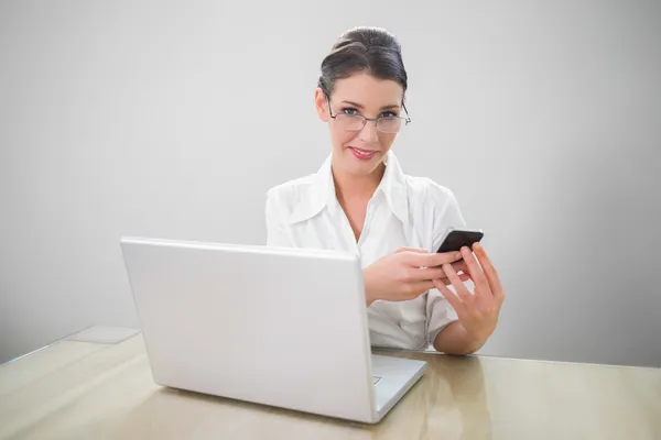 Cheerful businesswoman with classy glasses texting — Stock Photo, Image