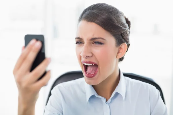 Mujer de negocios furiosa gritando a su teléfono móvil —  Fotos de Stock