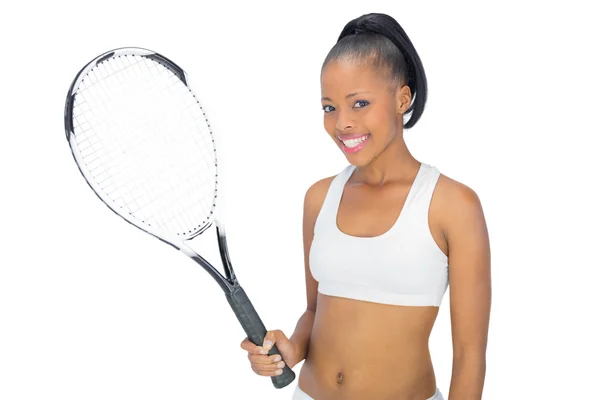 Улыбающаяся женщина в спортивной одежде держит теннисную ракетку — стоковое фото