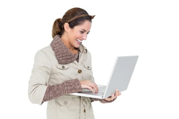 Zadowolony ładny brunetka w zimowe moda za pomocą laptopa — Zdjęcie stockowe