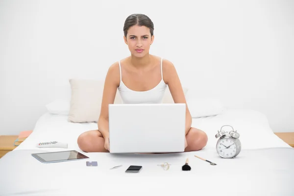 Model in white pajamas holding a laptop — Stock Photo, Image