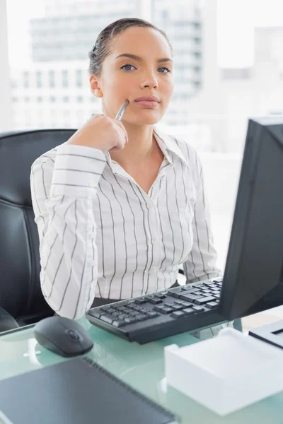 Tankeväckande affärskvinna sitter vid hennes skrivbord — Stockfoto