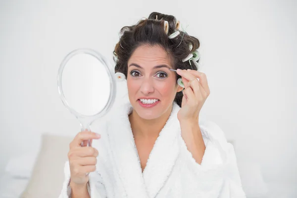 Smiling natural brunette using tweezers — Stock Photo, Image