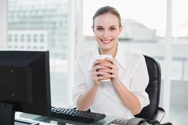 Businesswoman holding disposable cup smiling at camera — Stock Photo, Image
