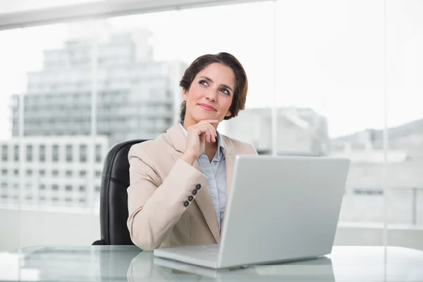 Nachdenkliche Geschäftsfrau mit Laptop am Schreibtisch — Stockfoto