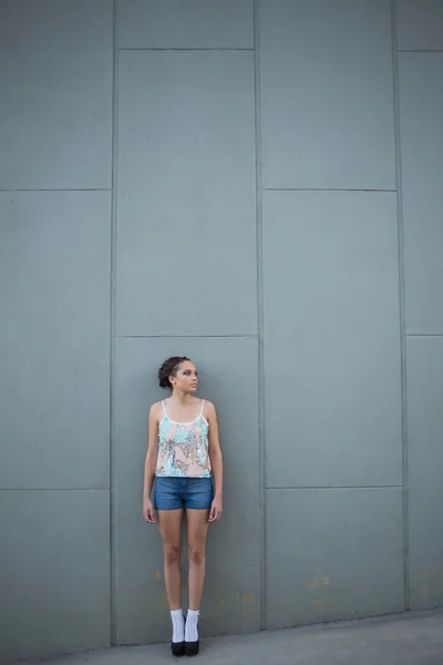 Bella donna con i tacchi alti in piedi di fronte a un muro grigio — Foto Stock