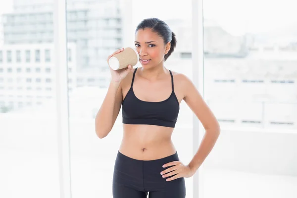 Nachdenkliches dunkelhaariges Model in Sportbekleidung beim Kaffeetrinken — Stockfoto