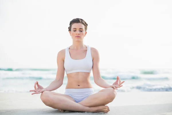 Modelo magro pacífica em sportswear branco meditando na posição de lótus — Fotografia de Stock