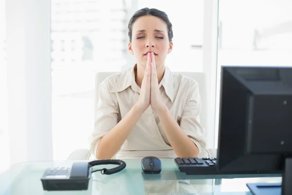Тревожная стильная брюнетка-бизнесвумен молится — стоковое фото