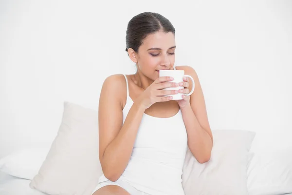 Model in white pajamas enjoying coffee smell — Stock Photo, Image