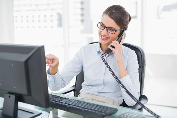 Femme d'affaires amusée répondant au téléphone — Photo