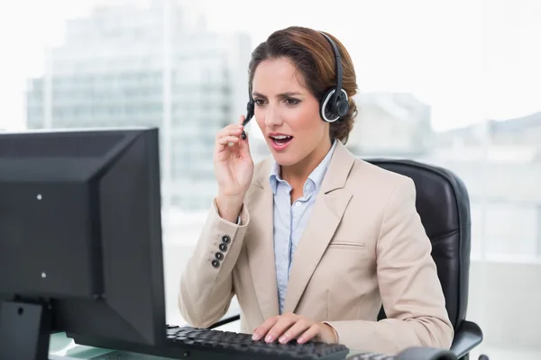 Angry businesswoman shouting in headset — Stock Photo, Image