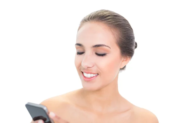 Uśmiechnięta młoda brunetka ważąca smartphone — Zdjęcie stockowe