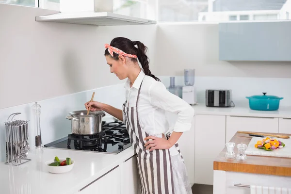 Koncentrovaný hezká žena s zástěra vaření — Stock fotografie