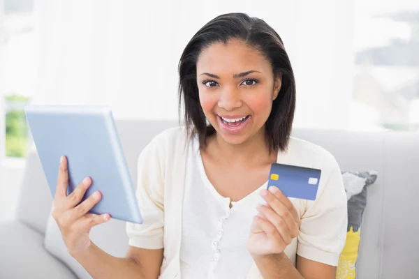 Heureuse jeune femme en vêtements blancs faisant du shopping en ligne avec une tablette PC — Photo