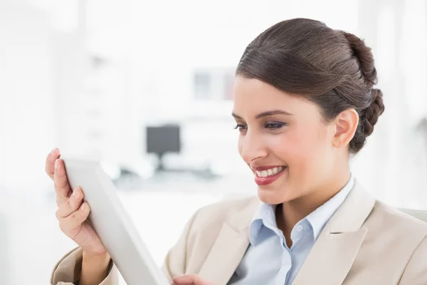 Amüsierte Geschäftsfrau blickt auf einen Tablet-PC — Stockfoto