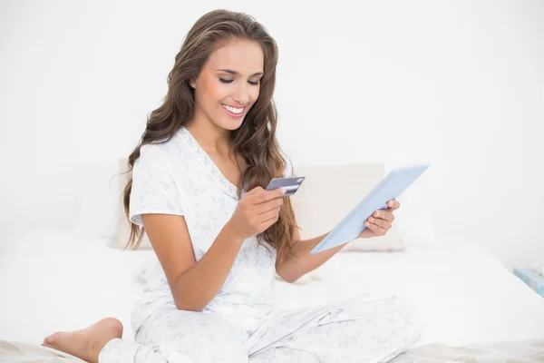 Morena segurando cartão de crédito e tablet — Fotografia de Stock