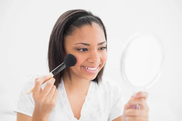 Joyful young model applying powder on her face — Stock Photo, Image