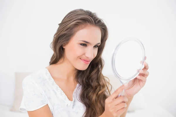 Grijnzend aantrekkelijke brunette op zoek naar spiegel — Stockfoto