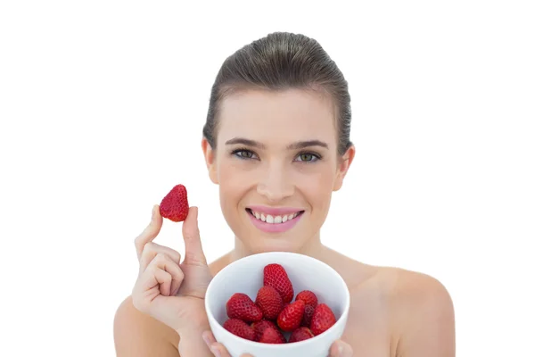 Beautiful model showing a bowl of strawberries — Stock Photo, Image