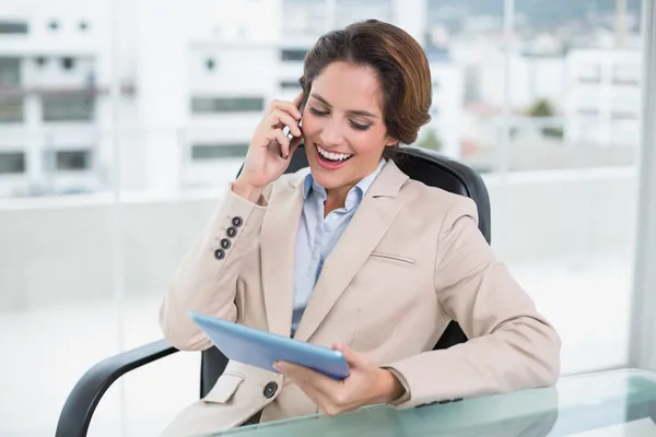 Empresária usando smartphone e segurando tablet — Fotografia de Stock