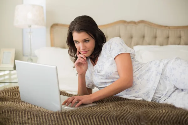 Pensando mujer bonita usando un ordenador portátil — Foto de Stock