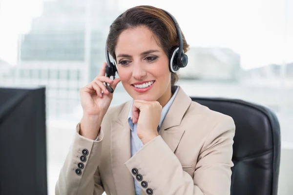 Cheerful businesswoman touching headset — Stock Photo, Image