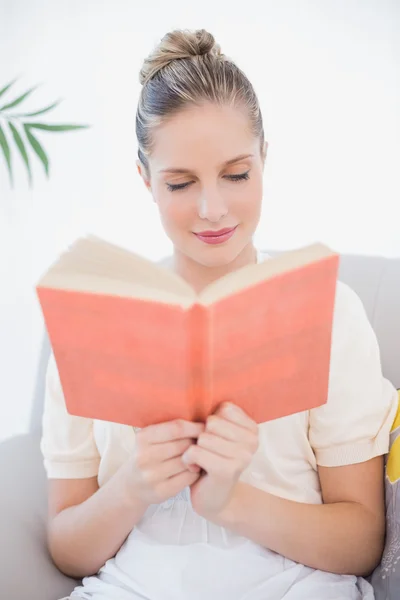 Peaceful fresh model reading book sitting on sofa — Stock Photo, Image