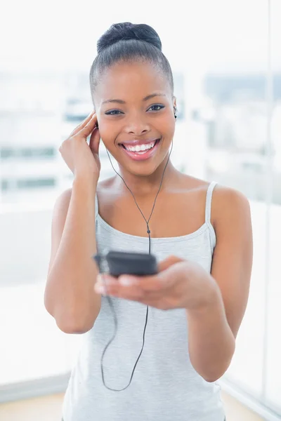 Lachende vrouw in sportkleding luisteren naar muziek — Stockfoto