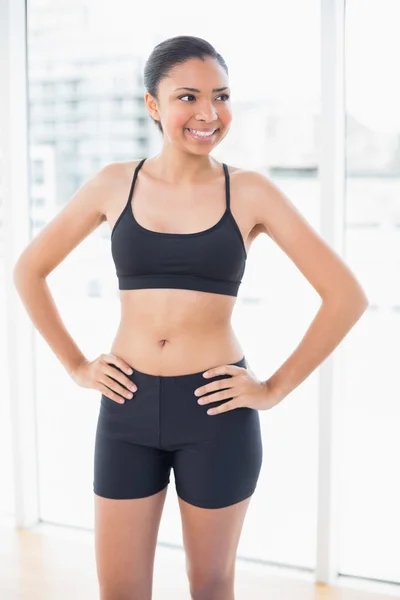 Amused model in sportswear posing with hands on the hips — Stock Photo, Image