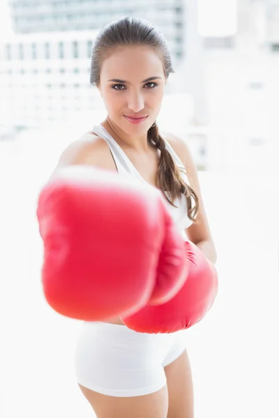 Sporty brunette boxing with red gloves — Stock Photo, Image