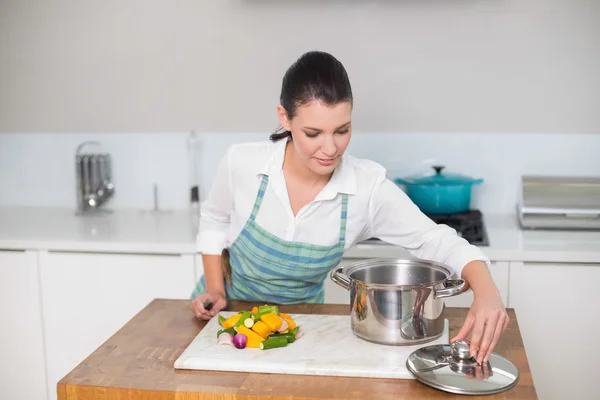 Vreedzame mooie vrouw dragen schort koken — Stockfoto