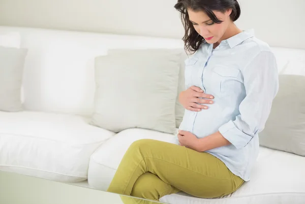 Atrakcyjna kobieta w ciąży trzymając jej brzuch — Zdjęcie stockowe