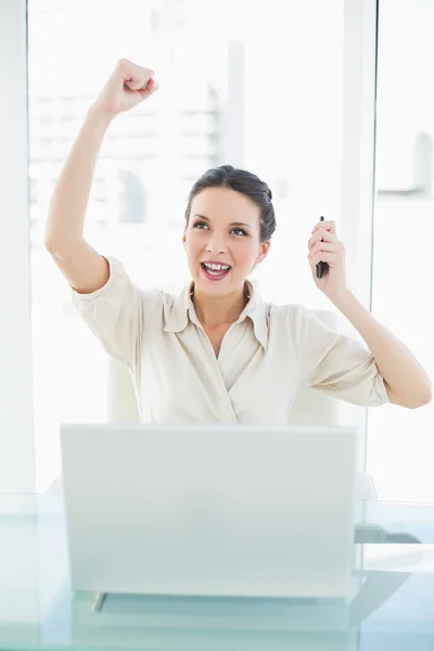 Уверенная стильная брюнетка-бизнесвумен, поднимающая кулак — стоковое фото
