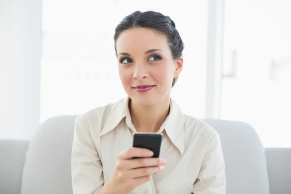 Drömmande snygg brunett affärskvinna med hennes mobiltelefon — Stockfoto