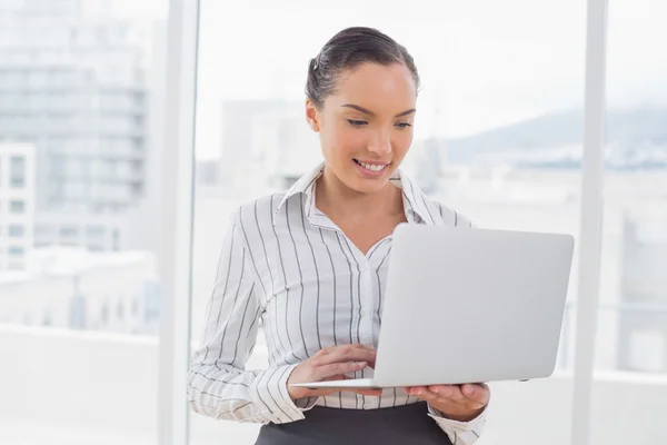 Geschäftsfrau steht und tippt auf Laptop — Stockfoto