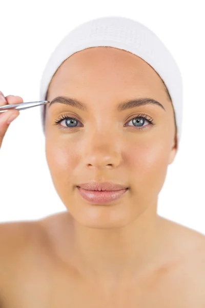 Pretty woman wearing headband using tweezers — Stock Photo, Image