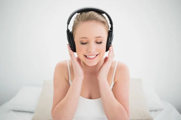 Blonde souriante naturelle écoutant de la musique avec les yeux fermés — Photo