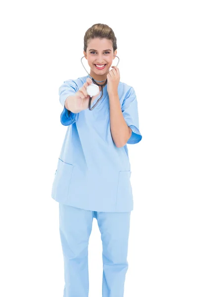 Забавная медсестра в синем халате играет со своим стетоскопом — стоковое фото